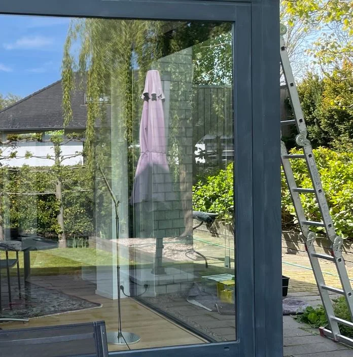 Antracietkleurig geschilderde schuifpui, detail van het buitenschilderwerk